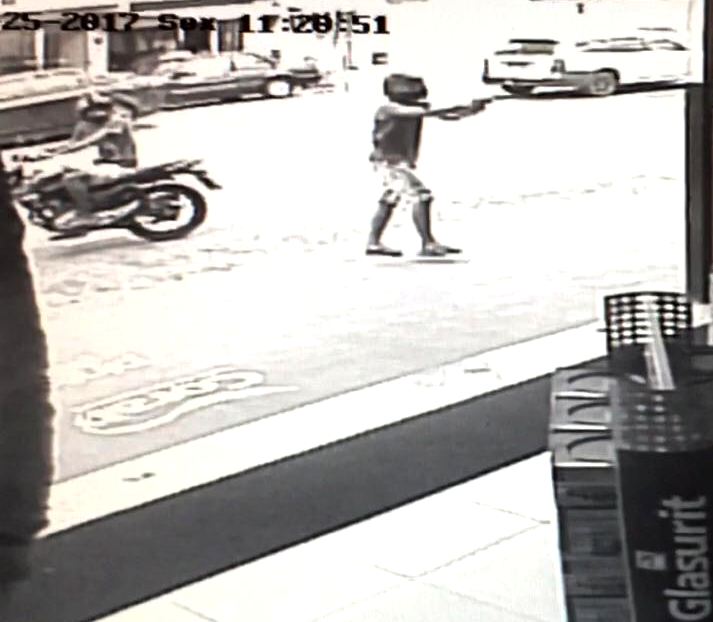 Homem armado invade comércio, assalta e atira contra carro de cliente